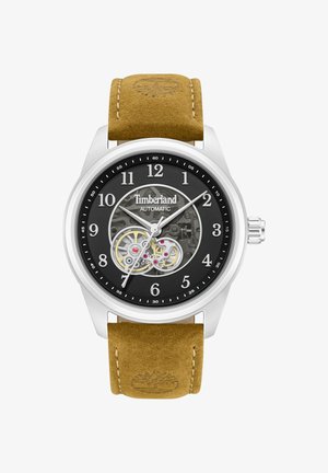 Automatické hodinky Timberland s čiernym ciferníkom, viditeľnými prevodmi, striebornými ručičkami, bielymi arabskými číslicami a opaskom z hnedej kože s reliéfnym logom stromu.