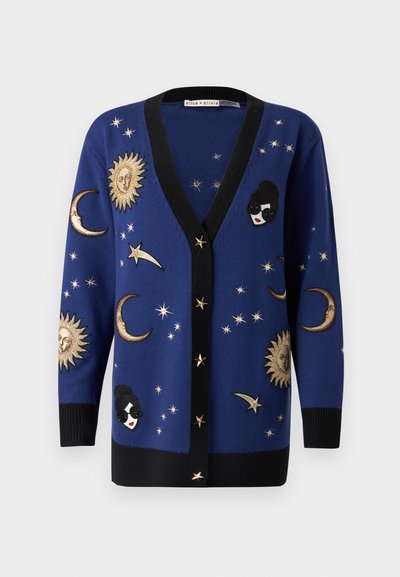 Cardigan di maglia blu con rifiniture nere, decorato con motivi dorati di sole e luna, stelle e una toppa decorativa a forma di volto.