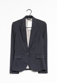 Blazer à rayures marines avec un col cranté, deux poches avant, une fermeture à un bouton et une doublure intérieure beige.