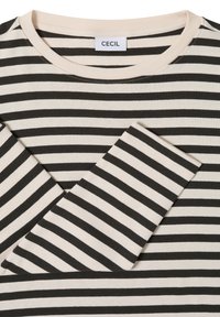 Czarna i kremowa koszula w paski z długim rękawem, z okrągłym dekoltem. Miękka tkanina z widocznymi przeszyciami wzdłuż krawędzi i kołnierzyka.