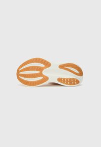 Suela de zapato blanca con una suela de goma naranja que presenta un patrón texturizado para mayor tracción; la zona central lisa muestra un logo en relieve.