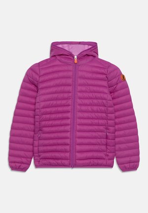 Veste matelassée légère violette avec capuche, fermeture éclair frontale, poignets élastiqués et poches latérales zippées, agrémentée d'un petit écusson rond orange sur la manche.