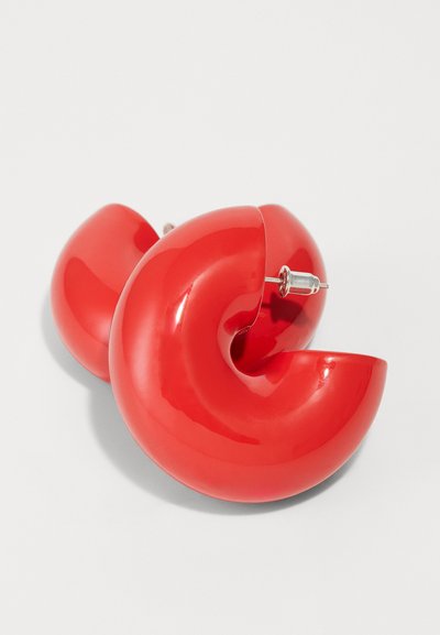 Rote, glänzende Plasticohrstecker in Form von Halbkreisen, mit einer glatten Oberfläche und einem Steckverschluss für sicheren Halt.