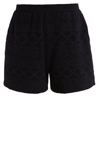 Shorts neri in tessuto a trama con un motivo testurizzato a forme di diamante, con un girovita elastico e una vestibilità morbida. Lunghezza a metà coscia.