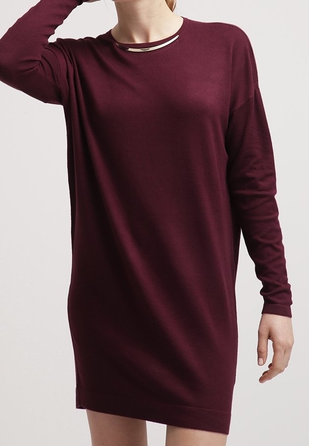 Robe bordeaux à manches longues avec un col rond et un accent métallique, présentant une coupe décontractée et une texture tricotée lisse.