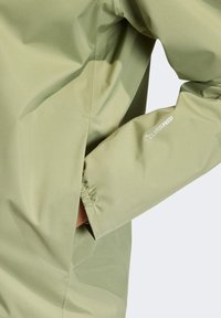 Svetlozelená nepremokavá bunda s elastickými manžetami, disponujúca bočnou vreckom a textom "CLIMAPROOF" na rukáve. Hladký povrch.