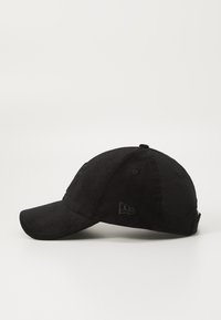 Black baseball cap with a curved brim, made of corduroy material. Features embroidered logo details on the front and side.