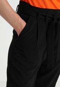 KIOMI Tygbyxor - black