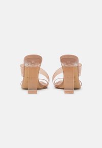 Naakte transparante high-heeled sandalen met een heldere blokhak en een ontwerp met open achterkant. Voorzien van delicate banddetails en een gladde textuur.
