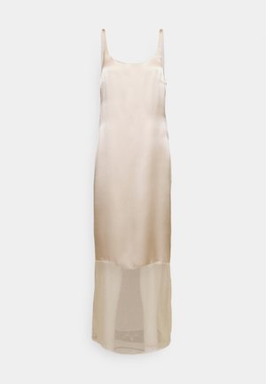 Σατέν μπεζ φόρεμα slip με λεπτές τιράντες, εφαρμοστή σιλουέτα και διαφανές κάτω μέρος που εκτείνεται μέχρι το μέσο της γάμπας.