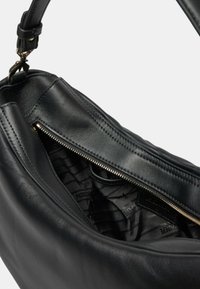 Borsa a tracolla in pelle nera con zip superiore, texture liscia e interno con motivo. La tracolla è regolabile con accenti in metallo dorato.