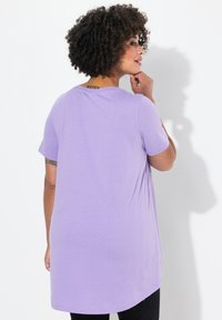 T-shirt violet à manches courtes avec une coupe décontractée, un col rond et un ourlet arrondi. Tissu doux et texture légère.