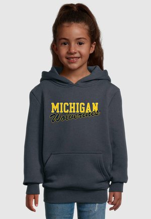 Pilkas medvilnės džemperis su gobtuvu, kuriame yra užrašas "MICHIGAN Wolverines" geltona ir mėlyna spalvomis. Įeina kengūros kišenė ir raukšlėti rankogaliai.
