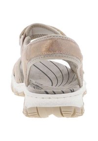 Sandal rose clair avec une tige texturée, une sangle ajustable, une semelle intérieure rembourrée et une épaisse semelle blanche avec un profil strié pour l'adhérence.