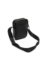 Čierna kožená crossbody taška s hladkým povrchom, obdĺžnikovým tvarom, prednou kapsou a nastaviteľným textilným popruhom. Zips na vrchu.