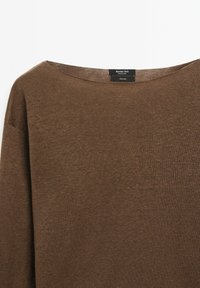 Hnědý lněný svetr se širokým výstřihem a texturovaným pletením. Na cedulce je nápis "Massimo Dutti" a jsou viditelné informace o údržbě.