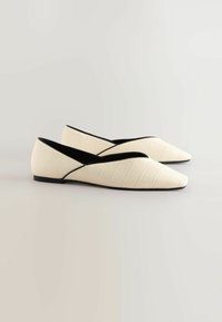 Spitze Ballerinas aus cremefarbenem Lederimitat mit Krokodileffekt, schwarzer Innenverkleidung und seitlichen Ausschnitten. Weiches, niedriges Absatzdesign.