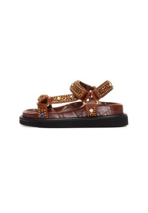 Sandalo in pelle marrone con suola nera, decorato con borchie dorate e pietre preziose multicolori su cinturini regolabili.