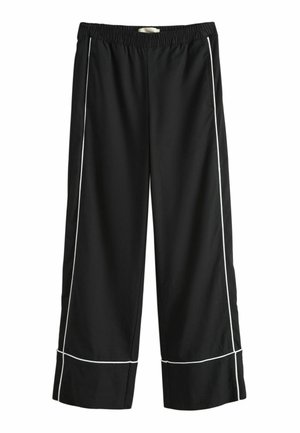 Čierne široké nohavice s elastickým pásom a bielymi vertikálnymi a horizontálnymi pruhmi pozdĺž nôh.