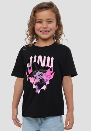 Lächelndes Kind mit lockigem Haar trägt ein schwarzes T-Shirt mit einem lila Comiccharakter, der einen schwarzen Hut und pinke Flammen hat, kombiniert mit hellblauen Jeans.