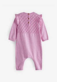 Barboteuse rose tricotée pour bébé avec manches longues, motif losange sur la poitrine, épaules volantées et trois boutons bruns dans le haut du dos.