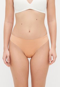 Hautfarbene, nahtlose Panties mit weicher Textur, niedrigem Schnitt und minimalistischem elastischem Bund für mehr Komfort.