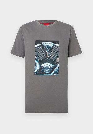 T-shirt grigia a maniche corte con una grafica dettagliata di un motore di motocicletta e il logo "HUGO" sul petto.