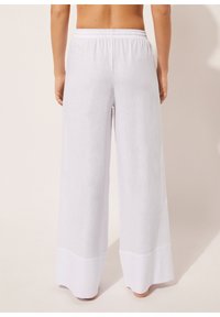 Vita, vida byxor gjorda av lättviktsmaterial; har en elastisk midja och en enhetlig fåll. Slät struktur med en avslappnad passform.