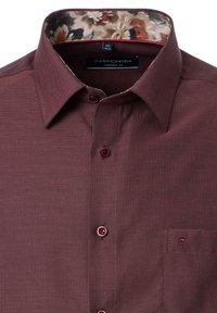 Burgunderfarbiges Hemd mit Knopfleiste und strukturierter Oberfläche, kontrastierendem blumenmusterlichem Innenspiegel und Logoakzent auf der Brusttasche.