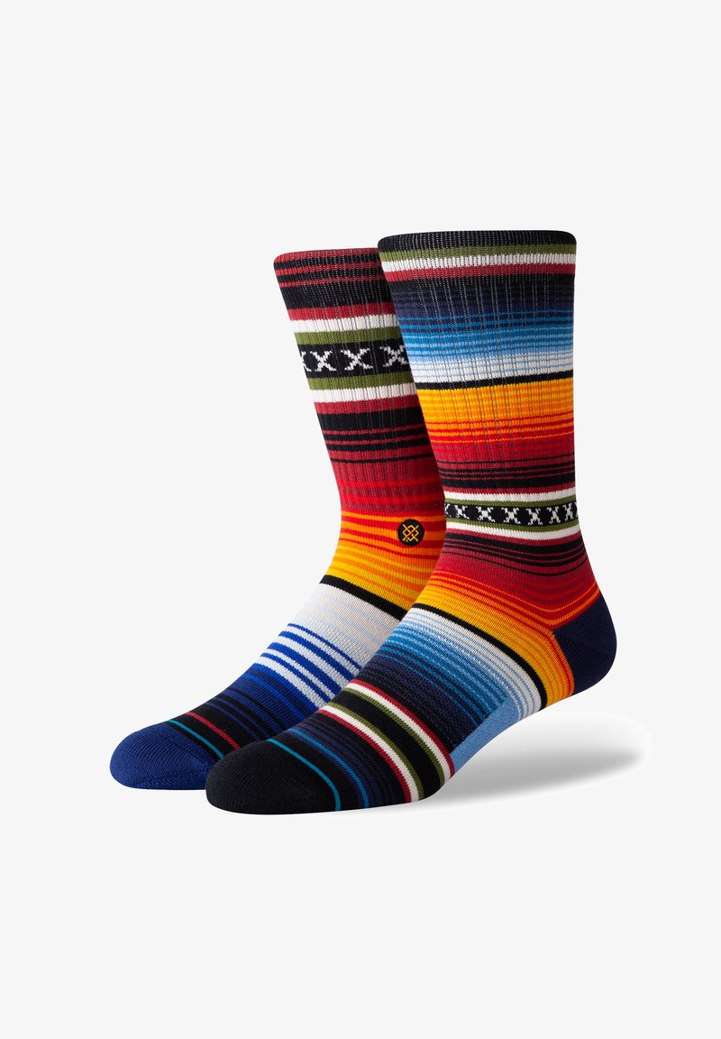 Multicolored socks featuring varied stripes in reds, blues, and yellows. Made of a soft knit with solid dark blue and black toes.