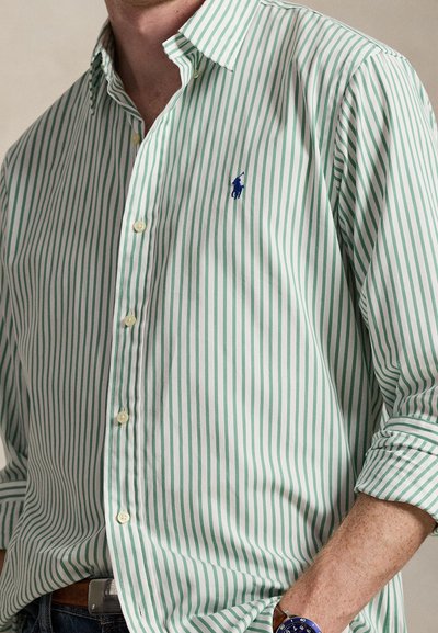 Button-up shirt with green and white vertical stripes. Features a collar, long sleeves, and a small blue logo on the left chest.