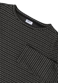 Maglione lungo nero con un tessuto texturizzato e a fantasia. Collo rotondo e piccolo dettaglio tasca sul davanti. Etichetta del marchio "CECIL" visibile.
