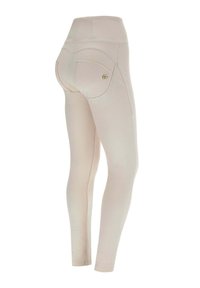 Leggings beige con vita alta, vestibilità aderente e due tasche posteriori. Tessuto morbido e cuciture minime con un piccolo logo decorativo.