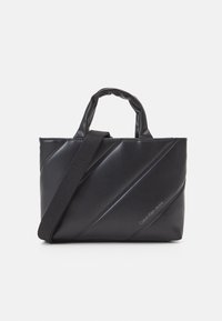 Black Calvin Klein Jeans handbag with diagonal padded design, two short handles, and a long adjustable shoulder strap.