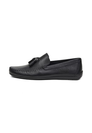 Mocassin pour homme en cuir noir avec pampilles, couture de style mocassin et semelle plate, vu de profil sur fond blanc.