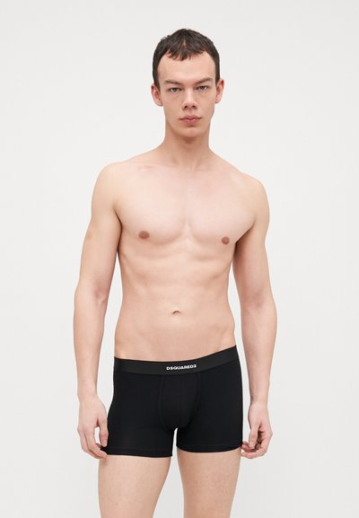 Boxer-briefs noirs en tissu extensible, dotés d'une ceinture élastique à logo. Le design est ajusté avec une coupe standard.