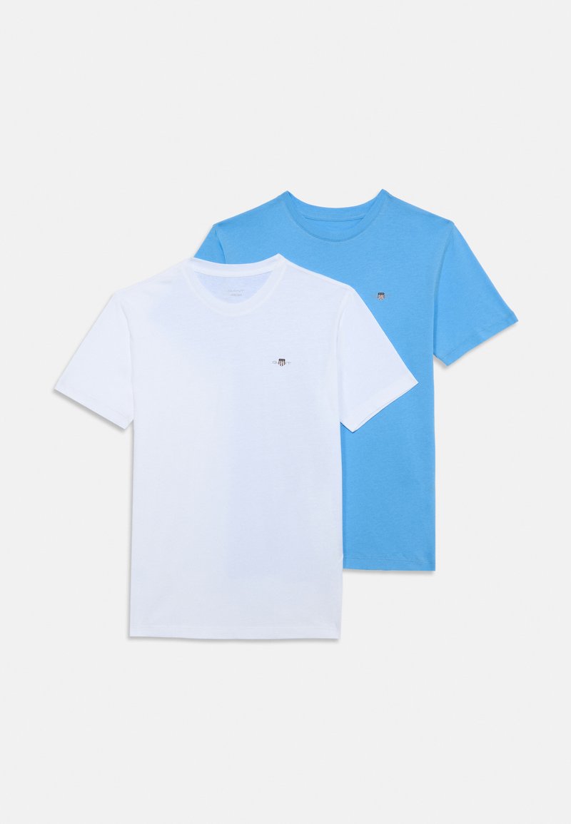 Två t-shirts med kort ärm: en vit och en ljusblå, tillverkade av bomull, med en liten logotyp på vänster bröst.