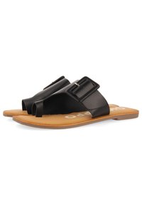 Sandales plates noires avec une large sangle et une grande boucle rectangulaire. Semelle intérieure beige avec un léger rembourrage, texture lisse et design minimaliste.