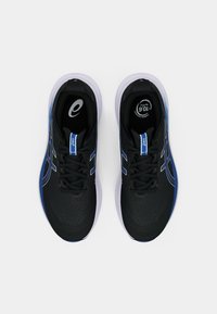 Chaussures de sport noires avec des accents bleus, présentant un dessus texturé, un design à lacets et une semelle gris clair. Logo visible sur la semelle intérieure.