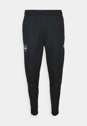 Pantalon de sport noir avec taille élastique, logo du club de football Arsenal sur la cuisse gauche, et logo Adidas bleu clair sur la cuisse droite.
