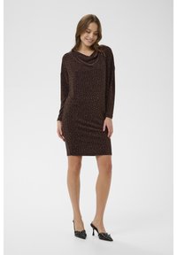 Pruun, põlveni ulatuv kleit koos lohkkaeluse, pikkade varrukate ja väikeste peegeldavate detailidega tekstuurse mustriga; koos mustade kontsadega.