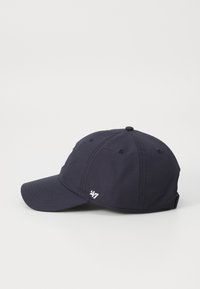 Navy cap with a curved brim, fabric texture, and embroidered logo on the front and side. Includes ventilation holes for breathability.