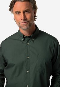 Camicia button-up di un verde scuro con un motivo sottile, dotata di colletto e tasca sul petto, realizzata in tessuto liscio.