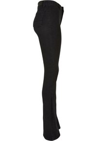 Jean noir taille haute slim flare avec cinq poches, vu de profil de la taille à l'ourlet.