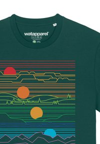 Groene katoenen T-shirt met horizontale lijnen in rood, oranje, geel, groen, blauw en paars, met zon- en berggrafische elementen.