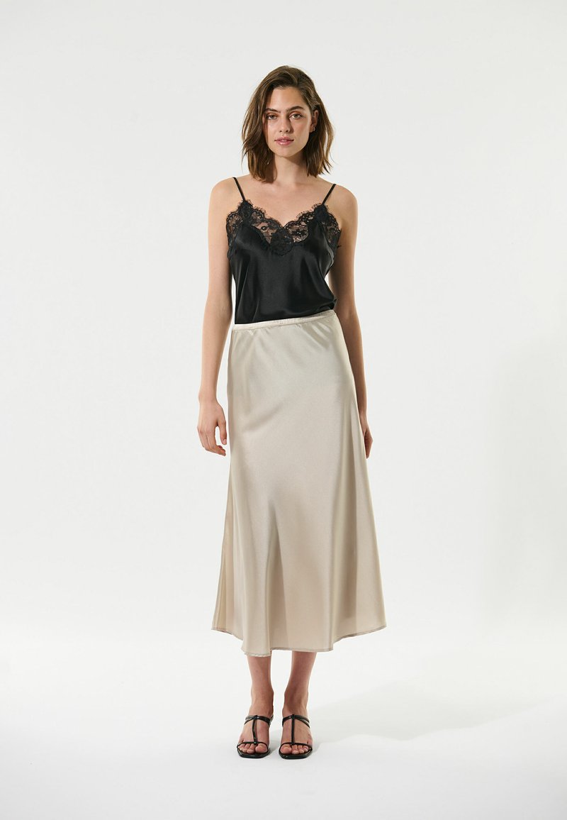 Camisole en satin noir avec délicat parement en dentelle, associé à une jupe maxi en satin beige clair. Design simple, texture lisse et longueur cheville.