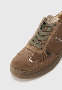Brune semsket sneakers med bronseakenter, teksturert overflate og grønne lisser. Har en avrundet tå og en gummisåle med geometrisk mønster.
