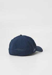 Navy blue cap with perforated fabric, curved visor, and button on top. Features three small white dots near the side. Soft texture.