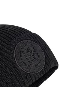 Berretto a maglia nero con texture a coste, dotato di un logo ricamato rotondo in nero sul davanti, che mette in evidenza linee pulite e un design minimalista.