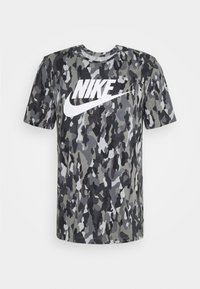 Grå kamouflage t-shirt i mjukt tyg, med en vit "NIKE"-logotyp i mitten. Kort ärm och rund halsringning.
